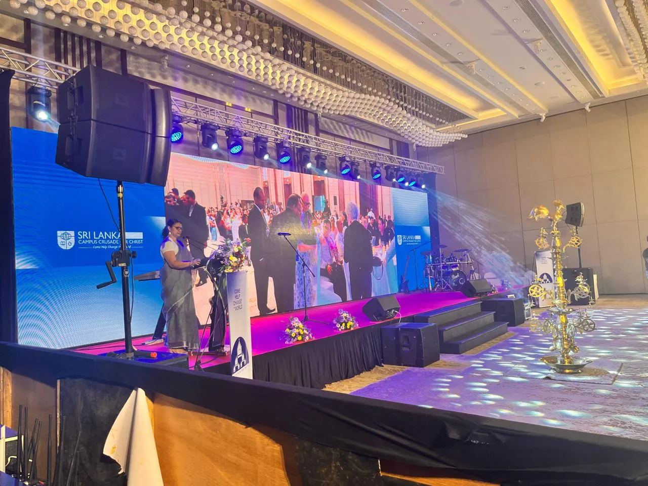 Event stage with speakers mounted and lighting rig overhead