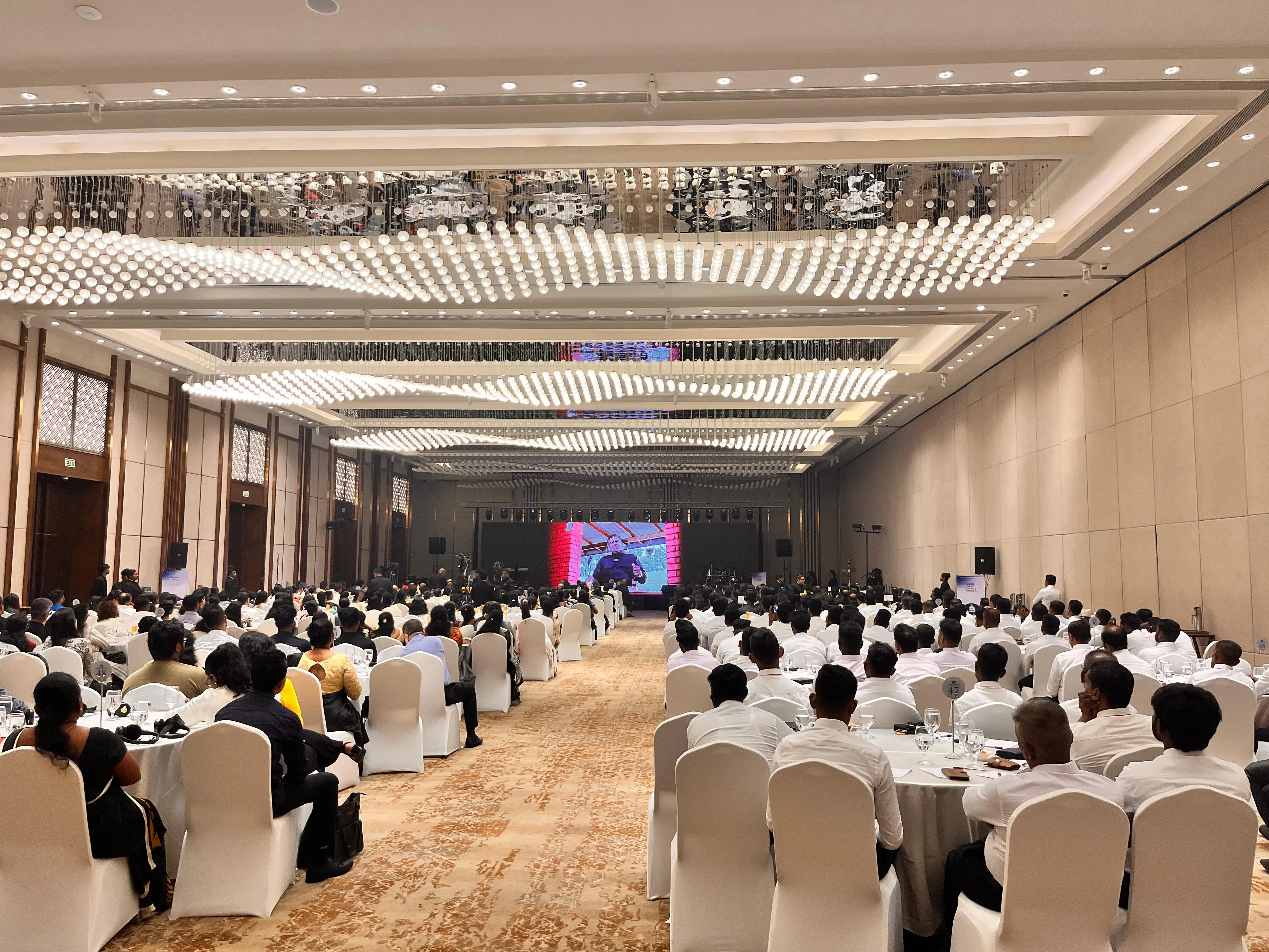 Full ballroom audience facing the stage