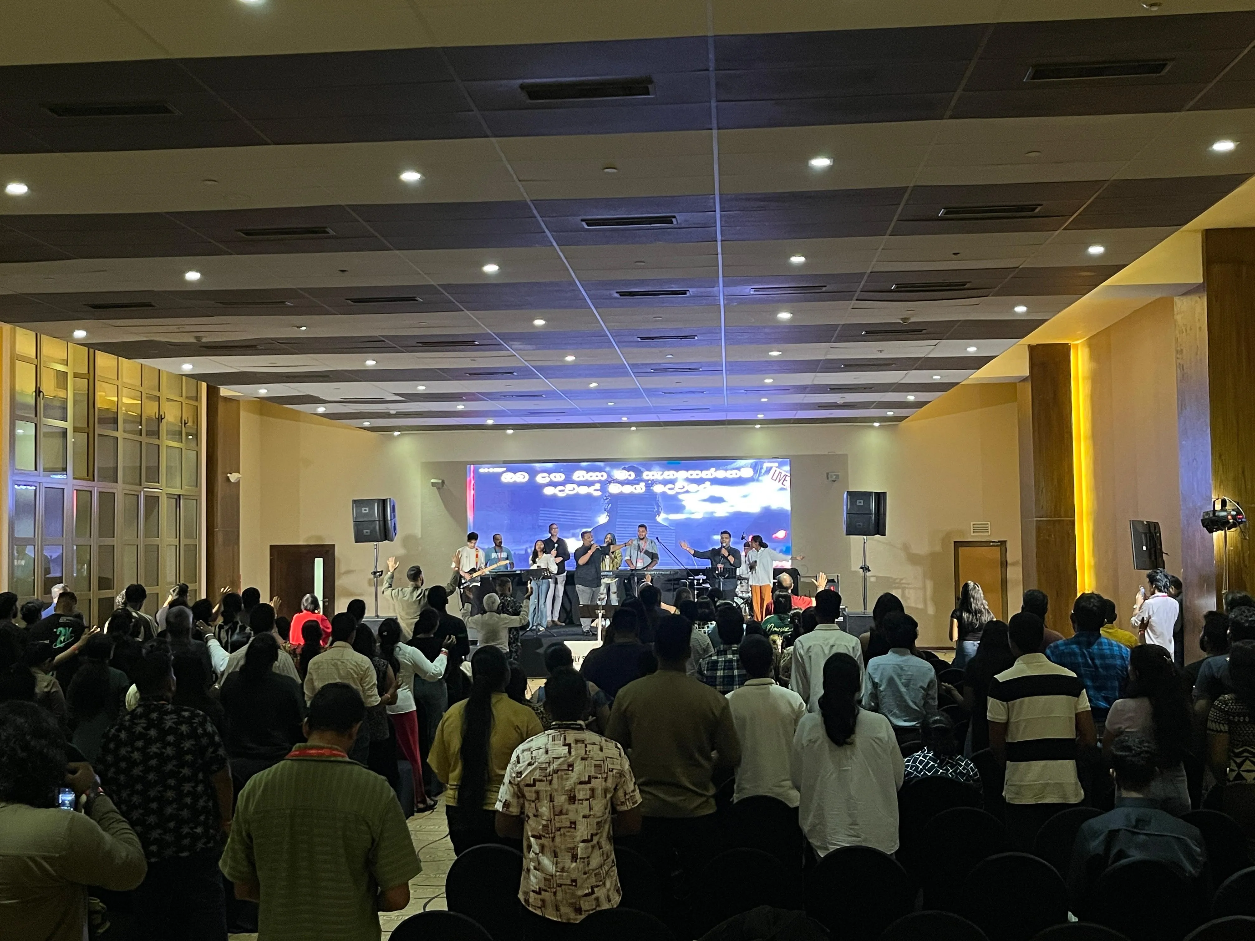 Gala event audience with stage lighting and coloured projection beams